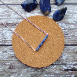 Blue Aventurine beaded bar suspended from silver tone necklace.