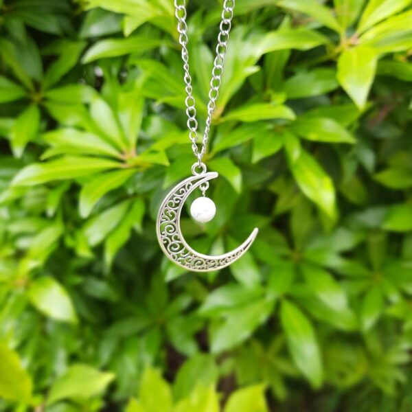Handmade moon charm necklace. Made with stainless steel chain and silver tone charm with a white/grey Howlite bead.
