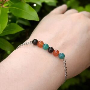 Handmade Mixed Agate Bracelet. Bracelet features a row of round Mixed Agate beads on a stainless steel wire. This is suspended from stainless steel chain. Bracelet shown worn on wrist.